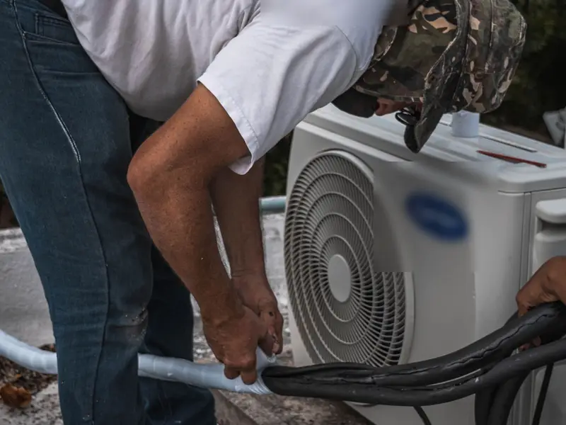 Technician servicing an outdoor AC unit