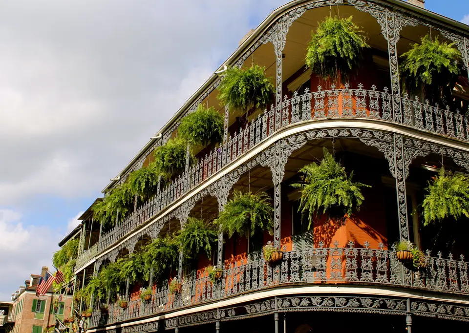 Wrought-iron galleries hung with ferns on a New Orleans street