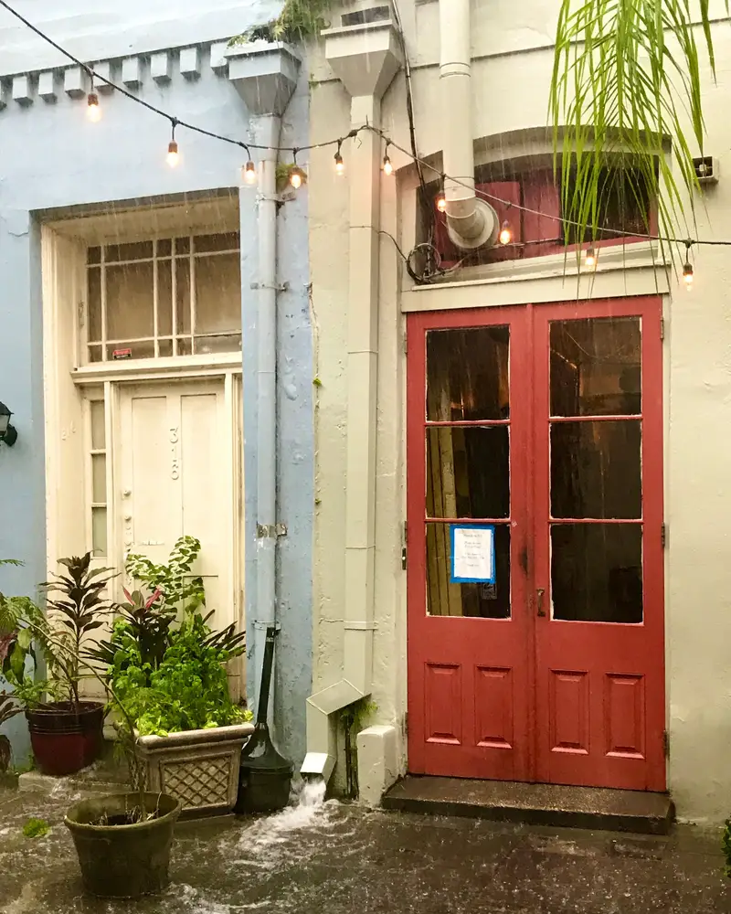Red shuttered doors in a New Orleans courtyard